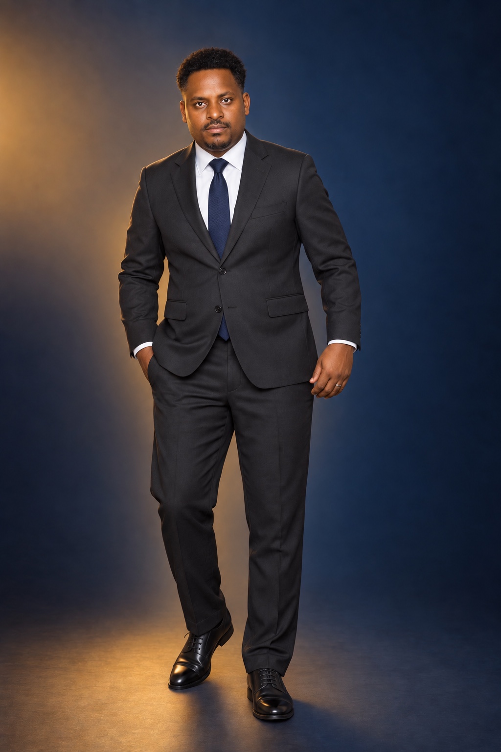 Full-length studio portrait of a man in a dark suit
