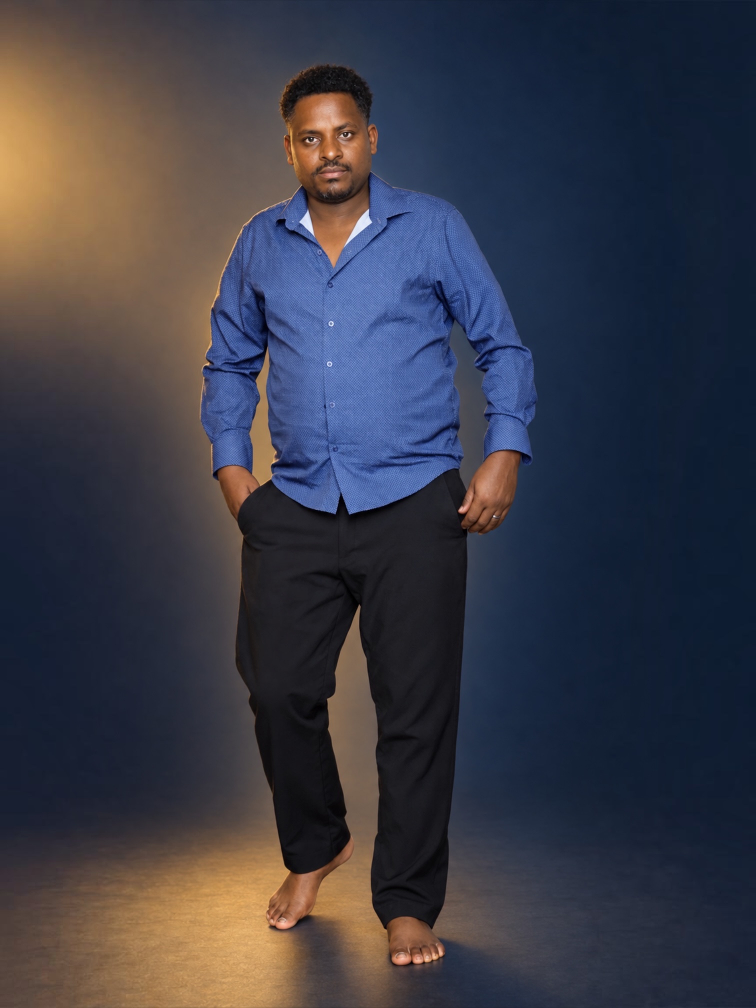 Second full-length studio portrait of a man in a blue shirt