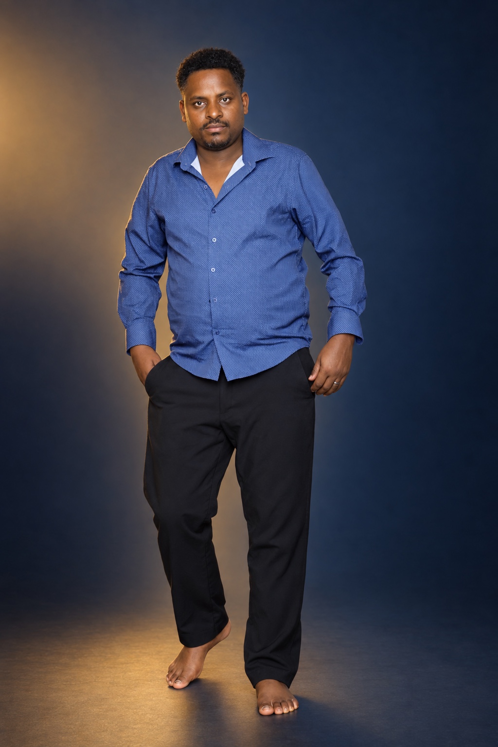 Full-length studio portrait of a man in a blue shirt